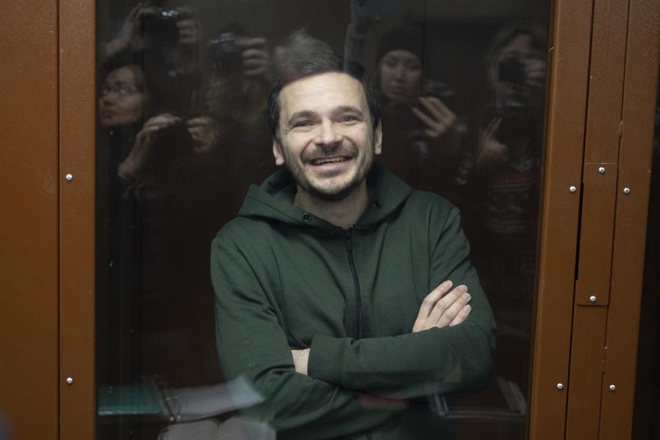 FILE - Russian opposition activist and former municipal deputy of the Krasnoselsky district Ilya Yashin smiles as he stands in a defendant's cubicle in a courtroom, prior to a hearing in Moscow, Russia, on Nov. 23, 2022. Mercenary chief Yevgeny Prigozhin led an armed rebellion against the Russian military, but faced no prosecution. Others, who merely voice criticism against the Kremlin, aren't so lucky. (AP Photo/Dmitry Serebryakov, File)