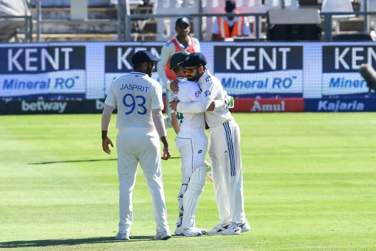 Virat Kohli (R) hugs Dean Elgar (C) after the South African captain's dismissal in his final Test innings (Rodger Bosch)