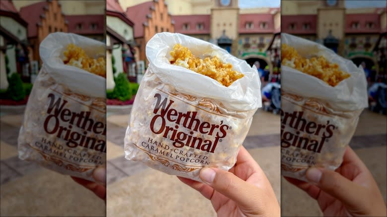 Hand holding bag of caramel popcorn