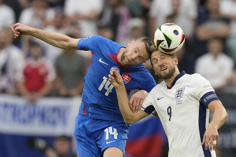 England's Harry Kane, right, jumps for the ball with Slovakia's Milan Skriniar during a round of sixteen match between England and Slovakia at the Euro 2024 soccer tournament in Gelsenkirchen, Germany, Sunday, June 30, 2024. (AP Photo/Antonio Calanni)