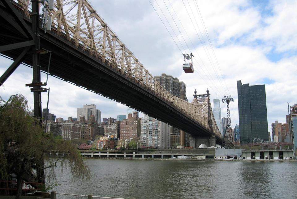 FILE - This May 1, 2014, file photo, shows the Roosevelt Island Tram crossing the East River to Roosevelt Island in New York. The island is getting its only hotel, the Graduate Roosevelt Island, in 2019. The boutique hotel will be located at the gateway to the new Cornell Tech campus. (AP Photo/Beth J. Harpaz, File)