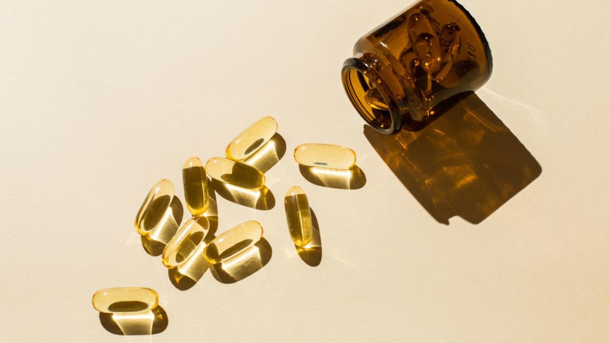 omega 3 fish oil capsules and a glass bottle on a beige background