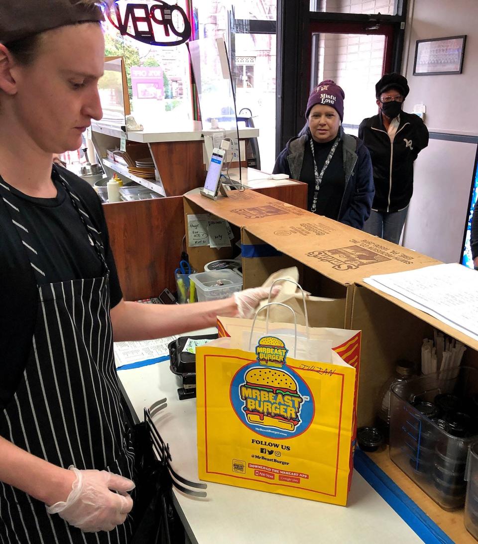 Corry Heard, an employee at New York Lunch, 922 East Ave., prepares to send out a delivery order for Mrbeast Burgers, one of the restaurant's virtual brands.