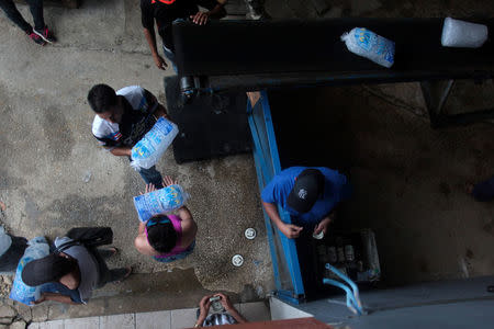 A woman buys ice at a local ice factory weeks after Hurricane Maria hit Puerto Rico in Orocovis, Puerto Rico, October 6, 2017. REUTERS/Alvin Baez