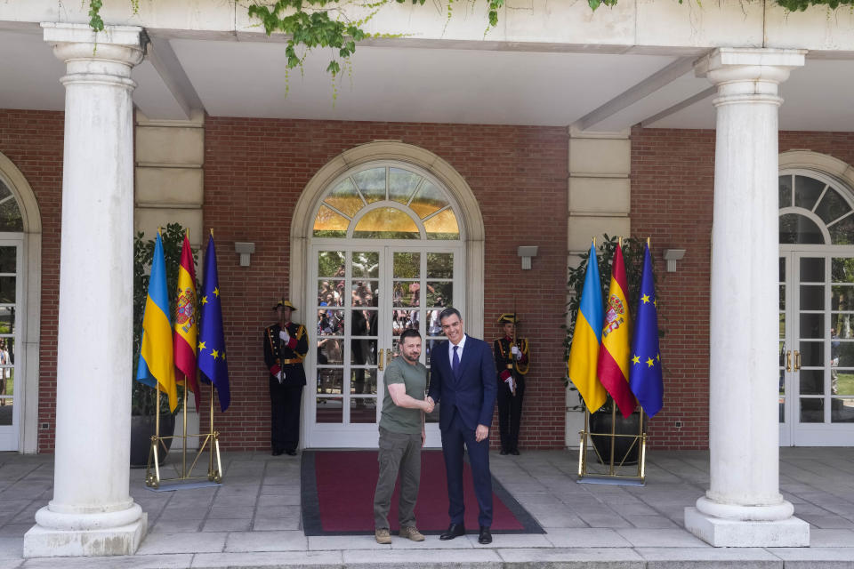 Ukrainian President Volodymyr Zelenskyy, left, is welcomed by Spain's Prime Minister Pedro Sanchez at the Moncloa palace in Madrid on Monday, May 27, 2024. (AP Photo/Paul White)