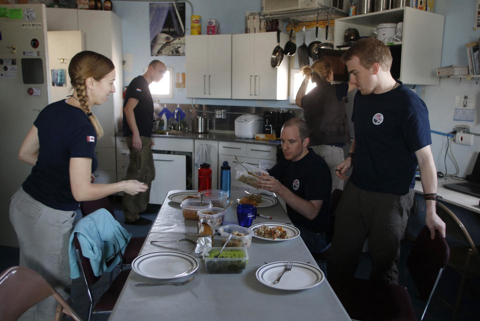 �Members of Crew 125 EuroMoonMars B mission prepare a meal at the Mars Desert Research Station (MDRS) outside Hanksville in the Utah desert March 2, 2013. The MDRS aims to investigate the feasibility of a human exploration of Mars and uses the Utah desert's Mars-like terrain to simulate working conditions on the red planet. Scientists, students and enthusiasts work together developing field tactics and studying the terrain. All outdoor exploration is done wearing simulated spacesuits and carrying air supply packs and crews live together in a small communication base with limited amounts of electricity, food, oxygen and water. Everything needed to survive must be produced, fixed and replaced on site. Picture taken March 2, 2013. REUTERS/Jim Urquhart