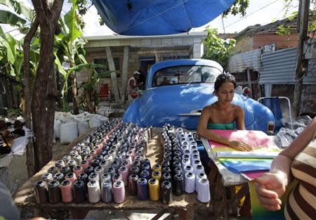 A woman waits for customers, as she sells coloured paper and spools of thread at her private stall at the entrance of her home in Havana October 4, 2013. REUTERS/Desmond Boylan