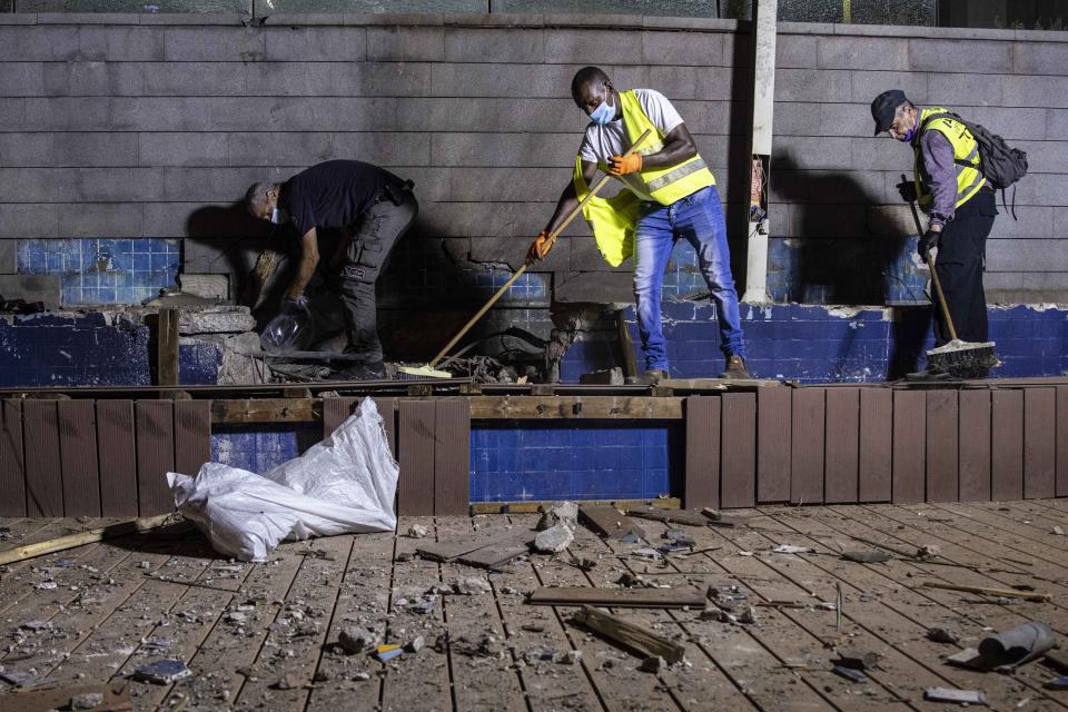 Israeli police inspect the damage at the site hit by a rocket fired by Palestinian militants from the Gaza Strip in the southern city of Ashdod, Israel, Tuesday, Sept. 15, 2020. The Israeli military says two rockets were fired from Gaza and one was intercepted by air defenses. Magen David Adom, the Israeli emergency service, says it treated two people for minor injuries from broken glass. (AP Photo/Tsafrir Abayov)