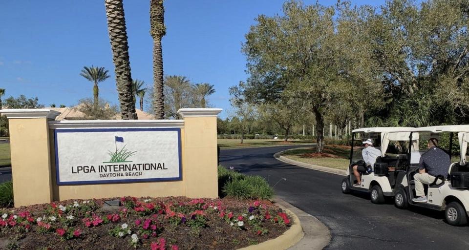 Golfers in golf carts head towards the clubhouse at LPGA International in Daytona Beach.