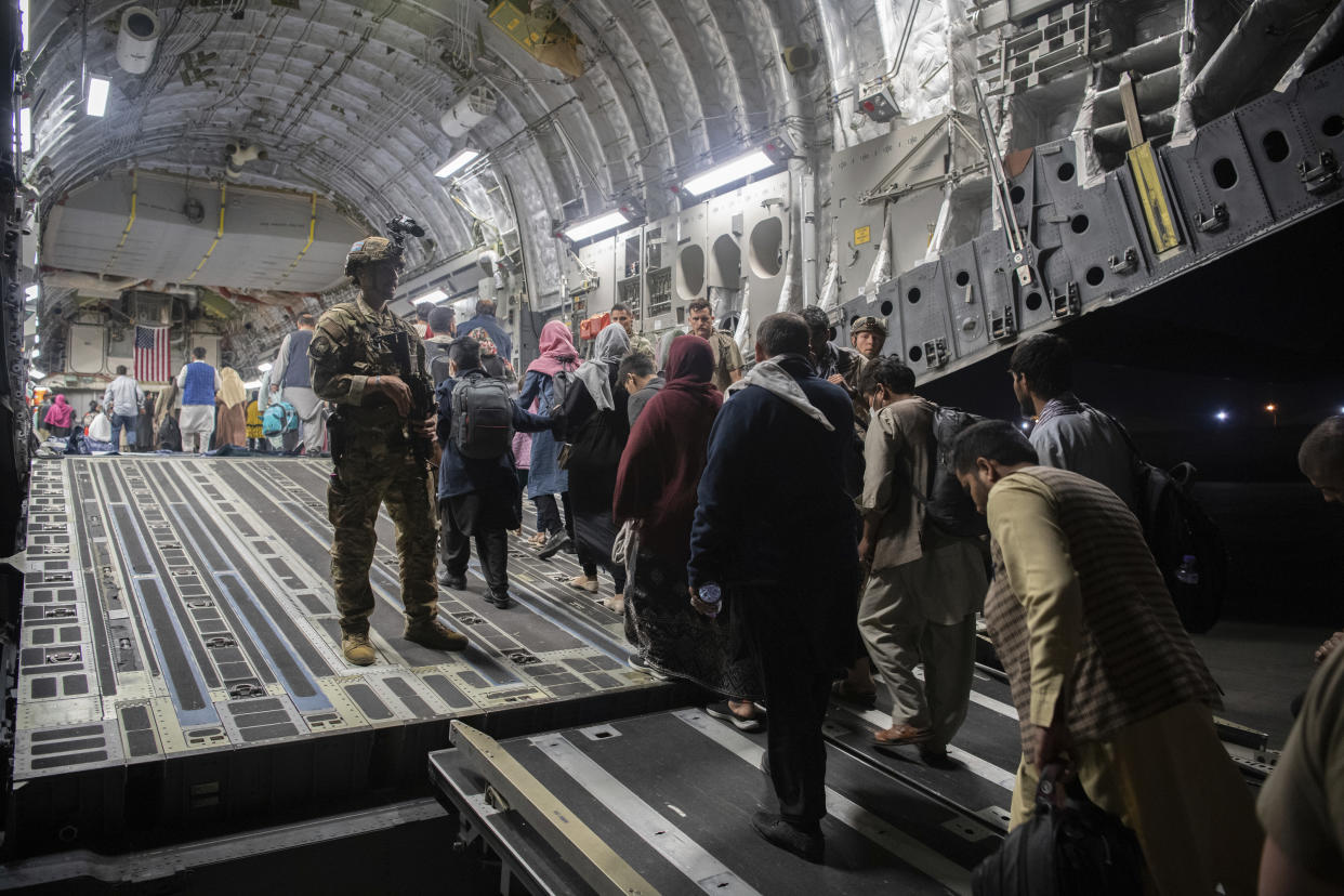 FILE - In this Aug. 22, 2021, file photo provided by the U.S. Air Force, Afghan passengers board a U.S. Air Force C-17 Globemaster III during the Afghanistan evacuation at Hamid Karzai International Airport in Kabul, Afghanistan. (MSgt. Donald R. Allen/U.S. Air Force via AP, File)