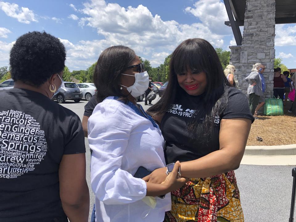 Park Springs elder care facility employee Nadia Williams, right, cries as she greets her mom, Anita Turner, at the facility in Stone Mountain, Ga., Saturday, June 13, 2020. Workers who agreed to live at Park Springs to keep its residents safe from the coronavirus are back with their loved ones for the first time in nearly three months. (AP Photo/Sudhin S. Thanawala)