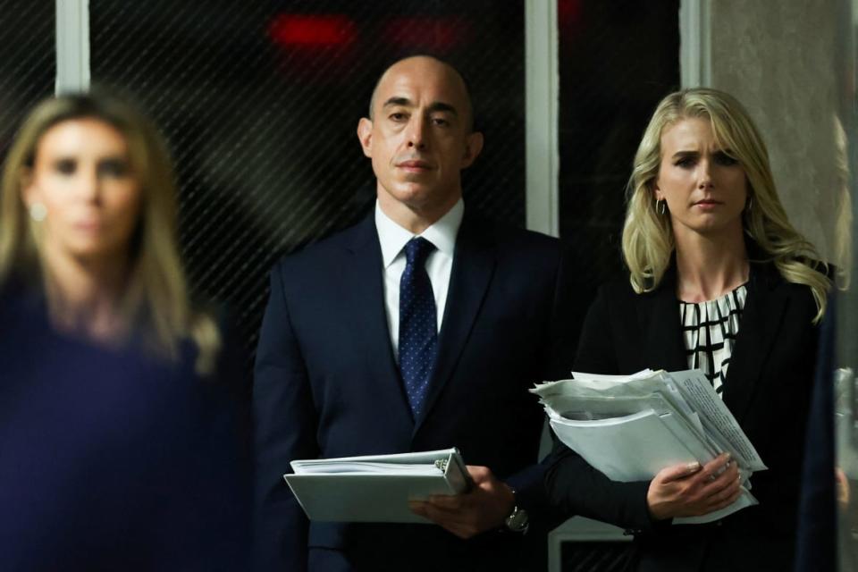 Three people lined up holding papers