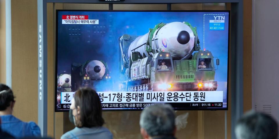 People watch a TV screen showing a news program reporting about North Korea's military parade with an image at a train station in Seoul, South Korea, Tuesday, April 26, 2022.