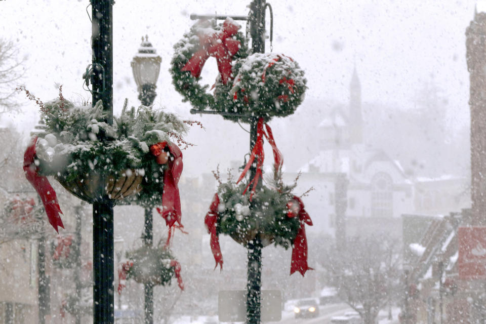 Snow clings to holiday decorations, Saturday, Dec. 5, 2020, in downtown Marlborough, Mass. The northeastern United States is seeing the first big snowstorm of the season. (AP Photo/Bill Sikes)