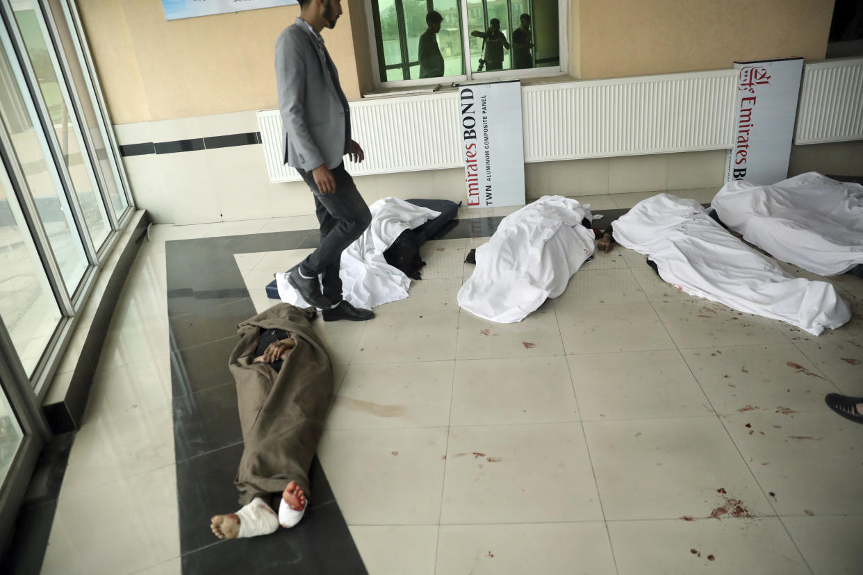 An Afghan man tries to identify the dead body at a hospital after a bomb explosion near a school in west of Kabul, Afghanistan, Saturday, May 8, 2021. A bomb exploded near a school in west Kabul on Saturday, killing several, many them young students, Afghan government spokesmen said. (AP Photo/Rahmat Gul)