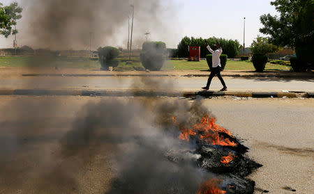 A Sudanese protester gestures as they burn tyres and barricade the road leading to al-Mek Nimir Bridge crossing over Blue Nile; that links Khartoum North and Khartoum, in Sudan May 13, 2019. REUTERS/Mohamed Nureldin Abdallah