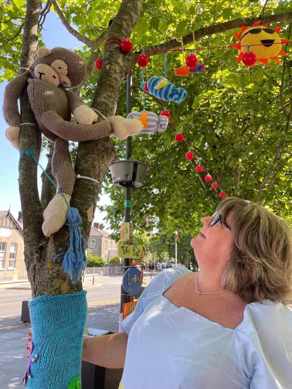 Monica with a knitted monkey in the yarn bombed town centre (Collect/PA Real Life).