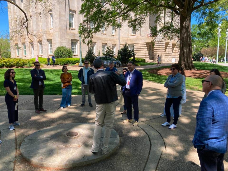 Ernest Dollar, executive director of the City of Raleigh Museum, talks with News & Observer journalists on the State Capitol grounds.