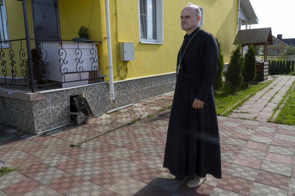 The Rev. Ioann Burdin stans at the courtyard of his house in the village of Nikolskoye, Kostroma Region, 91 km (57 miles) north-east of Moscow, Russia, Monday, July 17, 2023. Burdin wanted to leave the Russian Orthodox Church after he spoke out against Russia's decision to send troops into Ukraine at a small church near Kostroma, and the local court fined him for discrediting the Russian army. He asked the patriarch to approve his transfer to the Bulgarian Orthodox Church but instead, Kirill banned him from service until the priest made a public apology. (AP Photo)
