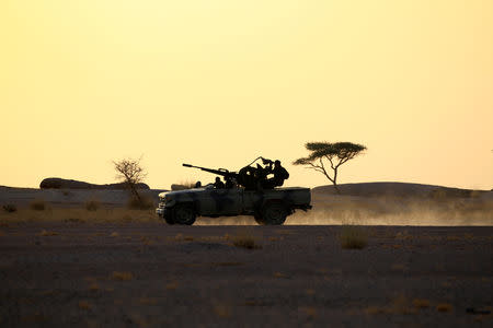 FILE PHOTO: The Polisario Front soldiers drive a pick-up truck mounted with an anti-aircraft weapon at sunset in Bir Lahlou, Western Sahara, Sept 9, 2016. REUTERS/Zohra Bensemra/File Photo