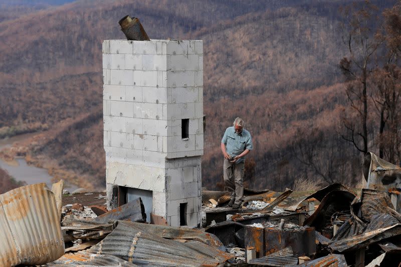 Donald Graham, 68, looks through the remains of his home which was destroyed by bushfires in Buchan, Victoria, Australia