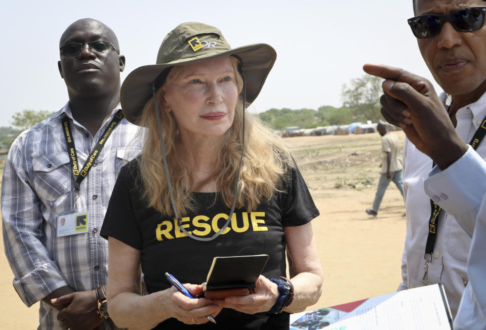 In this photo taken Tuesday, April 2, 2019, human rights activist Mia Farrow takes notes while speaking with staff from the International Rescue Committee while visiting an internally displaced person's camp in the capital Juba, South Sudan. Human rights activist Mia Farrow spoke to The Associated Press as she visited South Sudan again in her new role as envoy for the International Rescue Committee, helping the aid group to promote a global initiative to change the way humanitarian organizations approach malnutrition. (AP Photo/Sam Mednick)