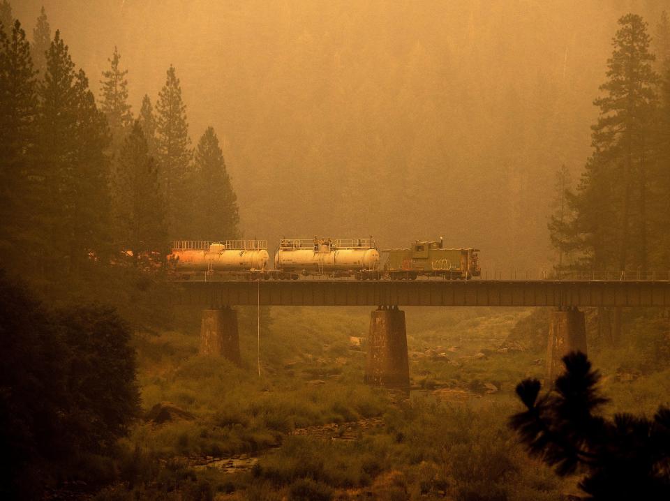 A fire train drives through the smoke and haze.