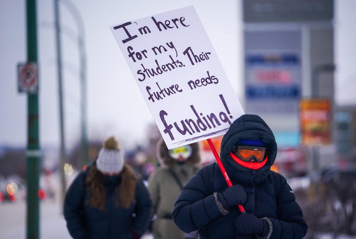 A person holds a sign at a demonstration in support of Saskatchewan teachers earlier this year. Teachers voted this week on a contract offer from the provincial government after months of job action. (Heywood Yu/The Canadian Press - image credit)