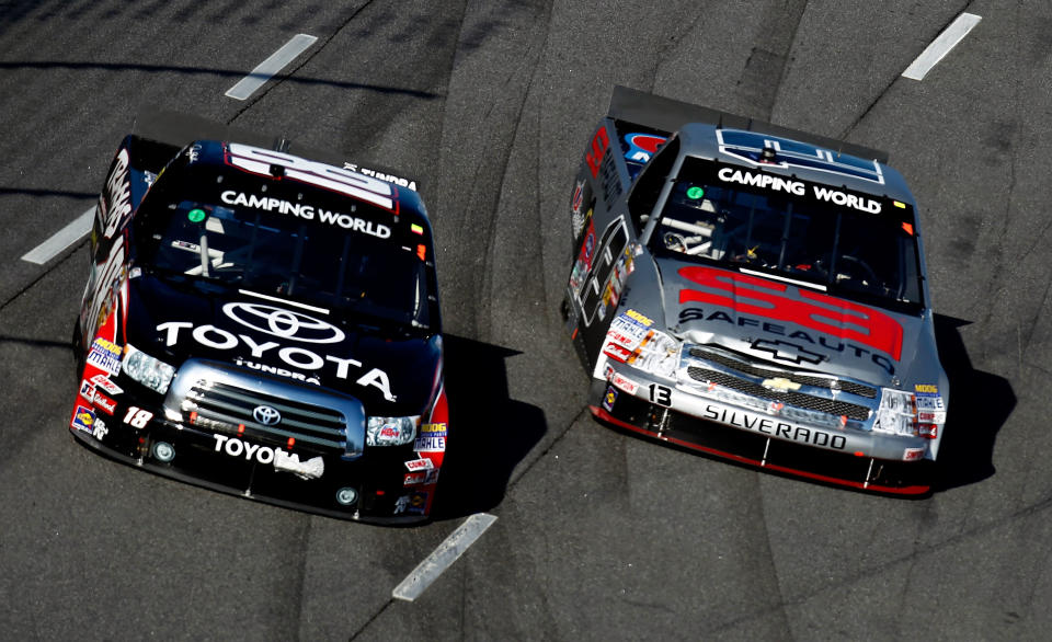 MARTINSVILLE, VA - OCTOBER 29: Denny Hamlin, driver of the #18 Toyota/Traxxas Toyota, races Johnny Sauter, driver of the #13 SafeAuto Insurance Co./Curb Records Chevrolet, during the NASCAR Camping World Truck Series Kroger 200 at Martinsville Speedway on October 29, 2011 in Martinsville, Virginia. (Photo by Jeff Zelevansky/Getty Images for NASCAR)