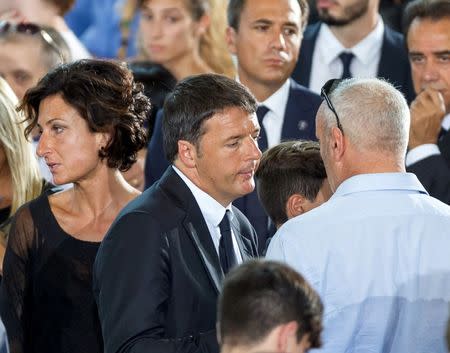 Italian Prime Minister Matteo Renzi (C) and his wife Agnese are seen after a funeral service for victims of the earthquake inside a gym in Ascoli Piceno, Italy August 27, 2016. REUTERS/Adamo Di Loreto