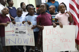 Children hold posters asking the Federal government to renew Temporary Protected Status during a press conference.