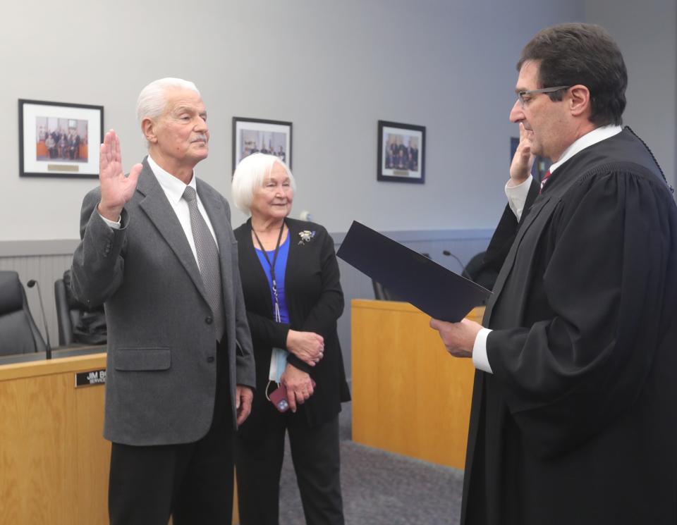 Allen Mavrides, left, stands with his wife, Larisa, as he is sworn in as Munroe Falls mayor by Ninth District Court of Appeals Judge Tom Teodosio.