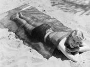 <p><em>Midnight Mystery</em> star June Clyde soaks up the sun underneath a cellophane blanket in 1932.</p>