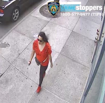 Police are searching for this mom wearing red, who allegedly dragged an 81-year-old woman to the ground by her hair. (Image: Courtesy of New York Police Department)