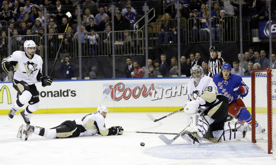 Pittsburgh Penguins goalie Marc-Andre Fleury (29), Rob Scuderi (4) and Matt Niskanen (2) look at the puck shot by New York Rangers' Carl Hagelin (62) for a goal during the second period of a second-round NHL Stanley Cup hockey playoff series Wednesday, May 7, 2014, in New York. (AP Photo/Frank Franklin II)