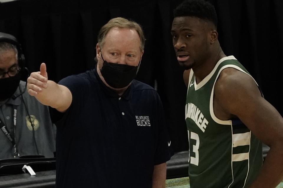 Milwaukee Bucks head coach Mike Budenholzer talks to Thanasis Antetokounmpo during the first half of an NBA basketball game against the Sacramento Kings Sunday, Feb. 21, 2021, in Milwaukee. (AP Photo/Morry Gash)