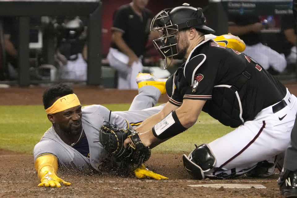 Arizona Diamondbacks catcher Cooper Hummel, right, tags out Milwaukee Brewers' Andrew McCutchen trying to score on a ball hit by Willy Adames during the fifth inning during a baseball game Saturday, Sept. 3, 2022, in Phoenix. (AP Photo/Rick Scuteri)