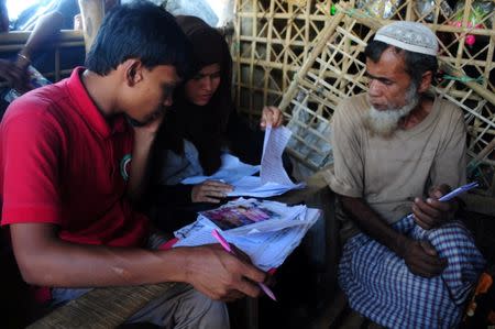 Bangladesh Red Crescent Society staff at a Rohingya refugee camp in Cox's Bazar, Bangladesh take down messages to be sent to the refugeesÕ family members in Myanmar June 28, 2018. Picture taken June 28, 2018. REUTERS/Zeba Siddiqui
