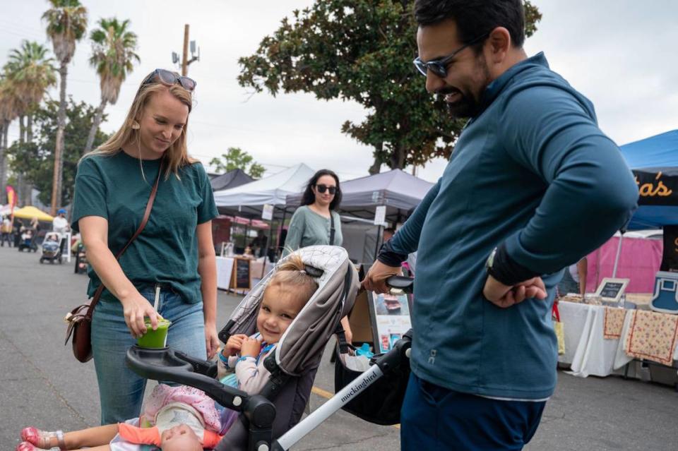 Natalie Gonzalez, left, Robert Gonzalez and their daughter Ellie, 3, purchase a drink from Green Smoothie Co. at the Midtown Farmers Market in Sacramento on July 27.