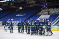 Vancouver Canucks goalie Braden Holtby, right, celebrates with his teammates after Vancouver defeated the Toronto Maple Leafs during an NHL hockey game in Vancouver, British Columbia, on Tuesday, April 20, 2021. (Darryl Dyck/The Canadian Press via AP)