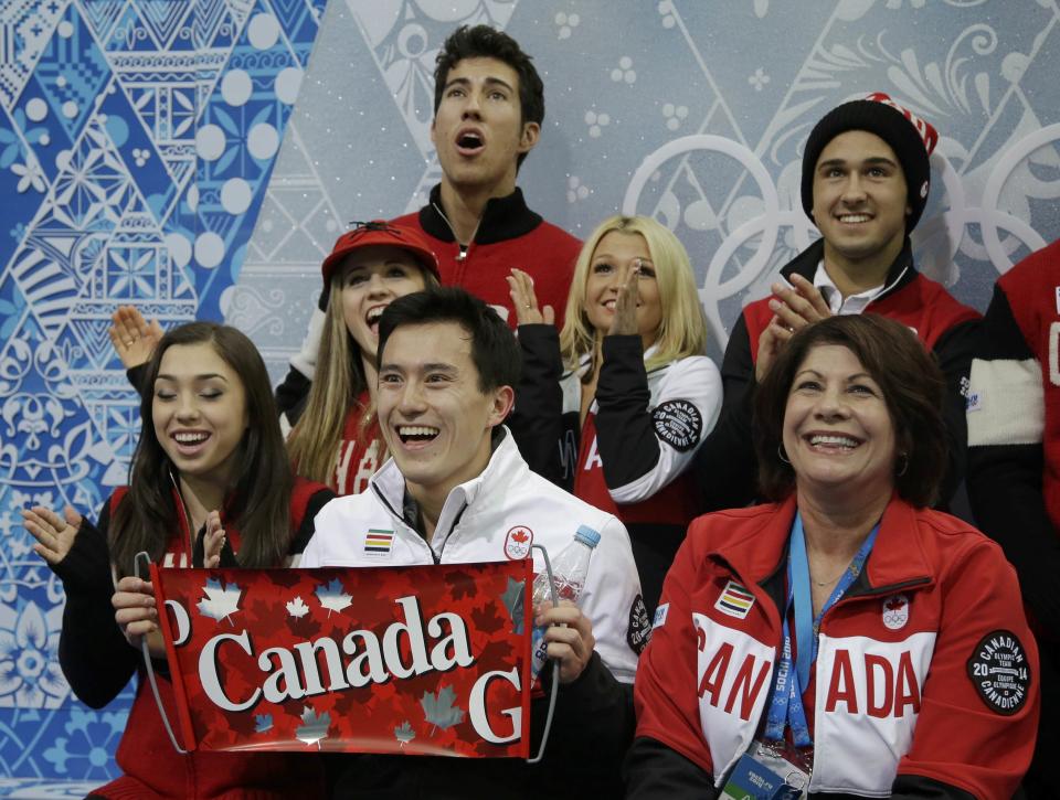 Patrick Chan of Canada celebrates with his team in the "kiss and cry" area during the Team Men Short Program at the Sochi 2014 Winter Olympics, February 6, 2014. REUTERS/Darron Cummings/Pool (RUSSIA - Tags: SPORT FIGURE SKATING OLYMPICS)