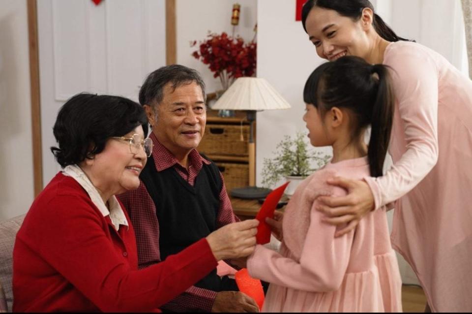 Senior elderly couple ang pow grandchildren Chinese New Year