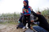 Syrian migrants cross under a fence into Hungary at the border with Serbia, near Roszke, August 26, 2015. REUTERS/Laszlo Balogh