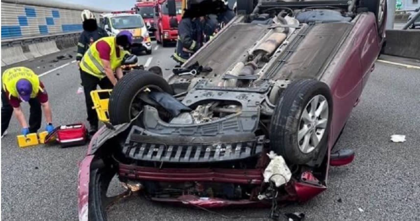 國2驚傳轎車鬼切釀車禍，紅色小客車遭撞180度翻覆在路中，駕駛受困車內，警消到場隨即將人救出，送醫後所幸並無大礙。（圖／翻攝畫面）