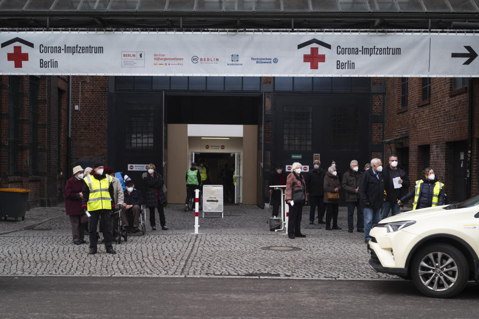 People wait for transportation as they leave the vaccination center against the COVID-19 disease in the district Treptow in Berlin, Germany, Thursday, Jan. 28, 2021. (AP Photo/Markus Schreiber)