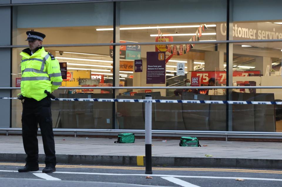 A police officer stands guard outside the supermarket on FridayNigel Howard