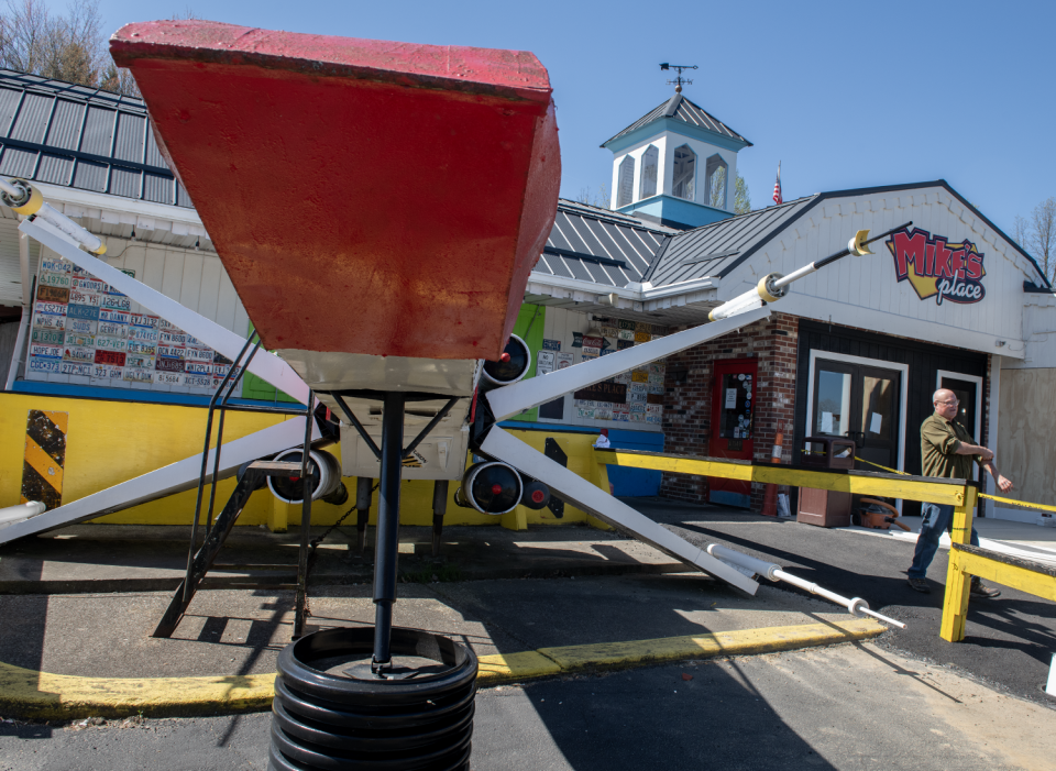 Mike's Place owner, Mike Kostensky, walks around the X-wing starfighter displayed in front of the Kent restaurant.