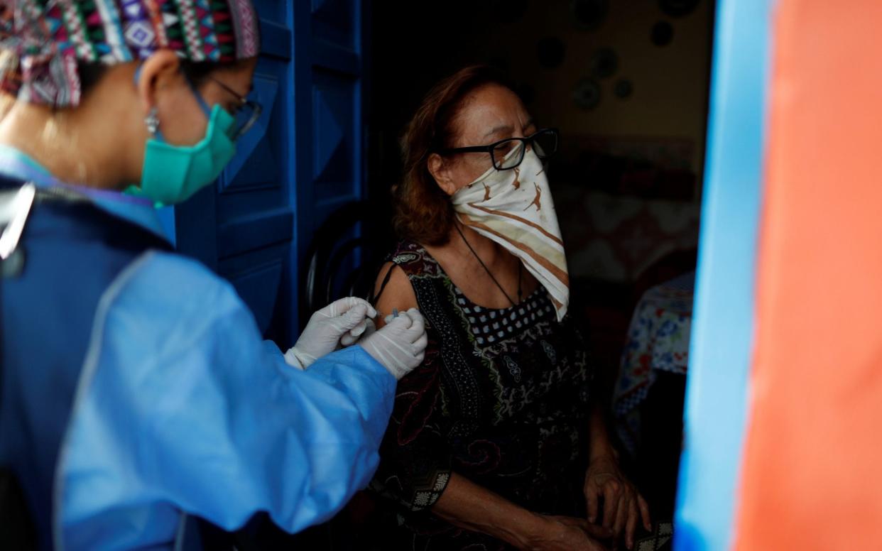 A healthcare worker vaccinates a woman as part of the start of the seasonal flu vaccination campaign near Buenos Aires, Argentina, as a part of a drive to prevent an influenza outbreak alongside Covid-19 - REUTERS/Agustin Marcarian