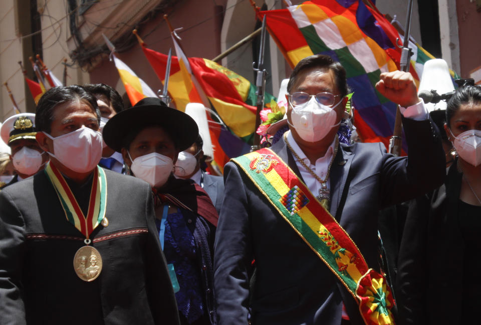 Bolivia's new President Luis Arce, right, raises his fist as he walks beside Vice President David Choquehuanca, left, on their inauguration day in La Paz, Bolivia, Sunday, Nov. 8, 2020. (AP Photo/Jorge Mamani)