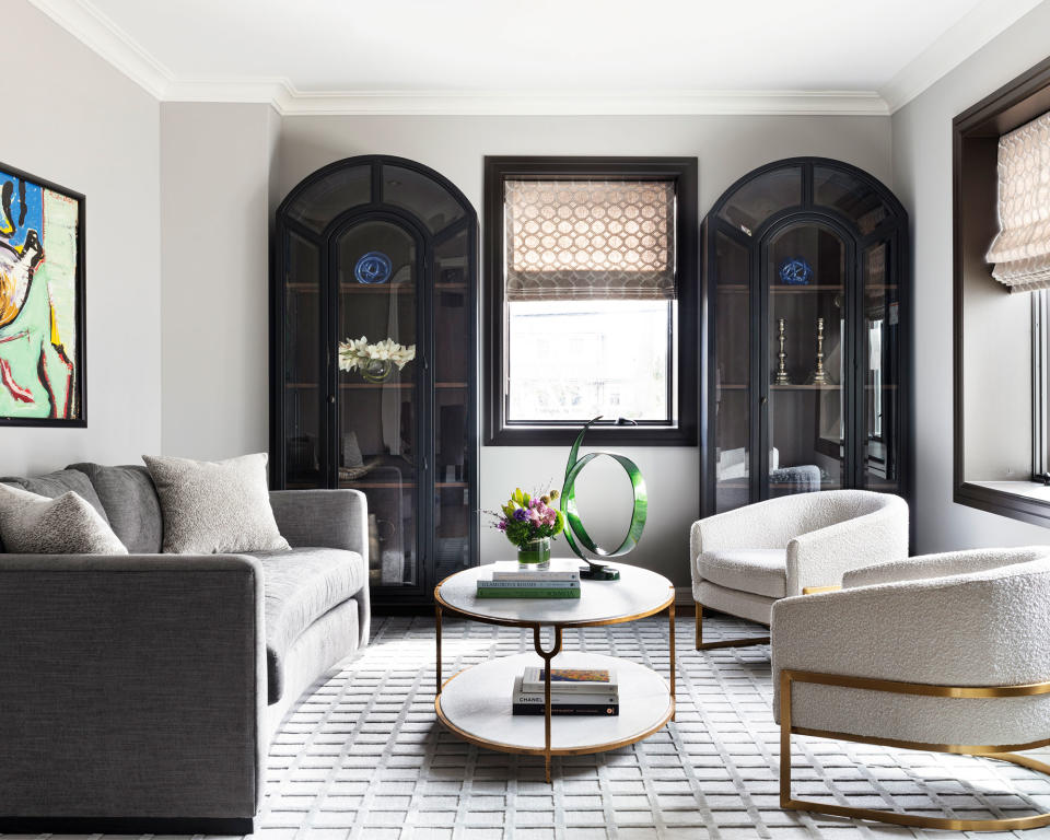 Modern living room with gray walls and flooring with black painted alcoves